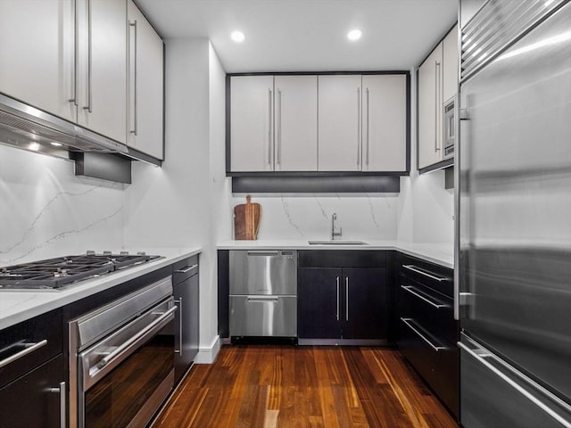 500 Atlantic Ave Unit 16R, Boston, MA 02210 - kitchen featuring appliances with stainless steel finishes, dark wood-style floors, tasteful backsplash, extractor fan, and recessed lighting
