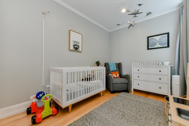 37 P St Unit 5, Boston, MA 02127 - bedroom featuring crown molding, a crib, wood finished floors, and baseboards