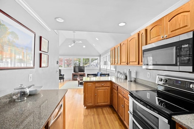 kitchen with a peninsula, light stone countertops, a ceiling fan, light wood finished floors, and stainless steel appliances