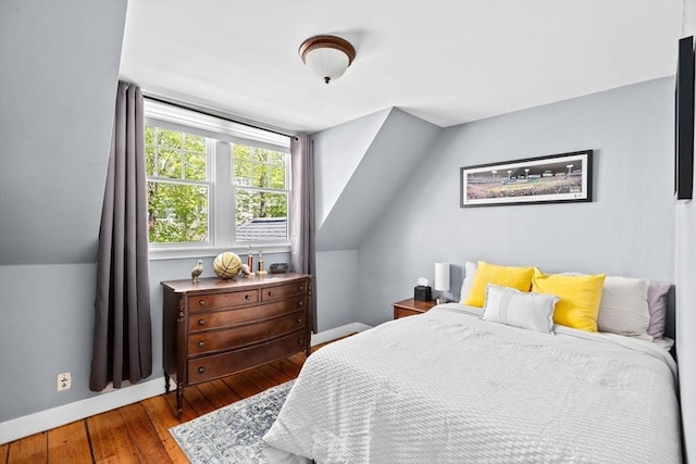 bedroom featuring baseboards, lofted ceiling, and hardwood / wood-style floors