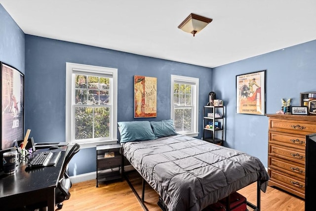 bedroom featuring multiple windows and light wood-style floors