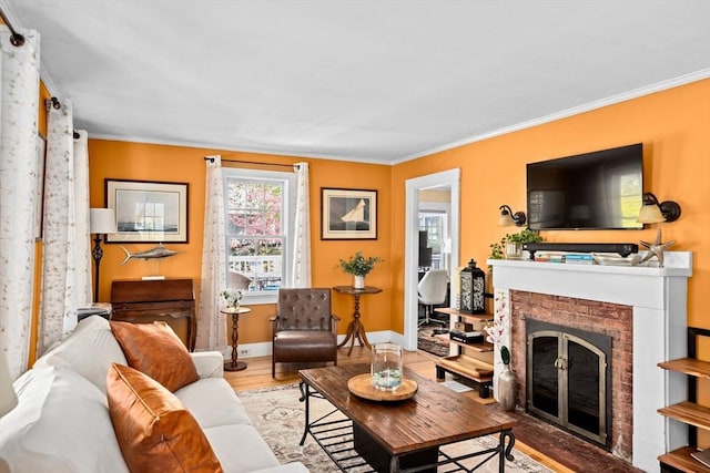 living room featuring crown molding, baseboards, a fireplace, and wood finished floors