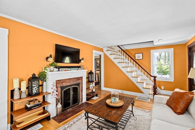 living room with crown molding, stairway, and a fireplace