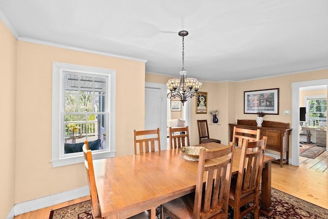 dining room with crown molding, wood finished floors, and a chandelier