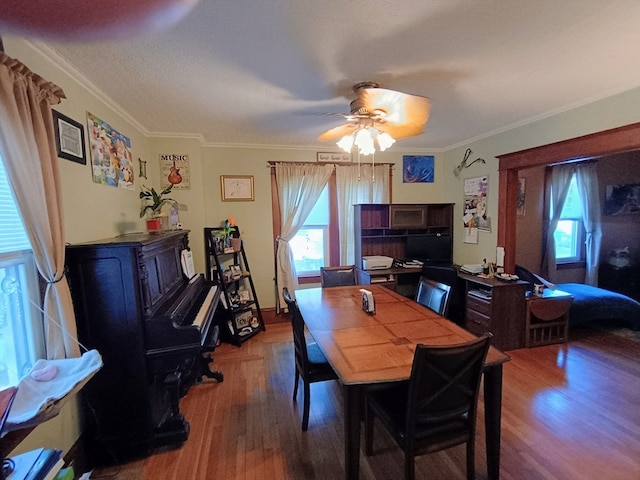 dining room with hardwood / wood-style floors, a healthy amount of sunlight, and ornamental molding