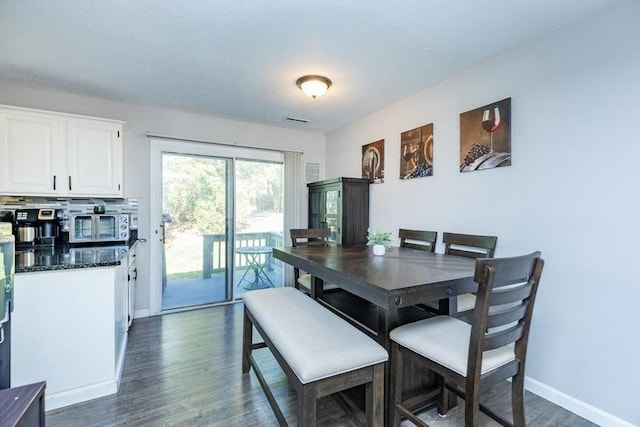 dining room with baseboards, dark wood-style floors, and visible vents