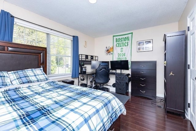 bedroom with baseboards, a textured ceiling, and hardwood / wood-style flooring