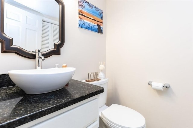 half bathroom with vanity and toilet