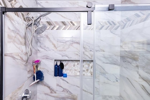 interior details featuring a marble finish shower