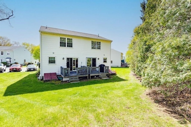 back of property with a lawn and a deck