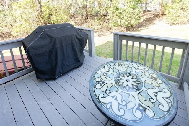 wooden deck featuring a grill