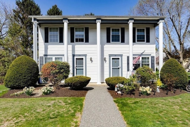 neoclassical home with a front lawn and covered porch