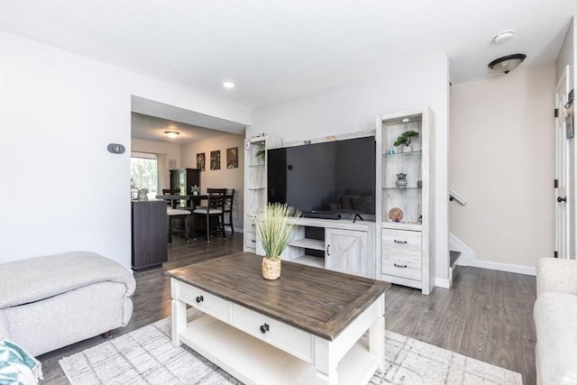 living area with recessed lighting, stairs, baseboards, and wood finished floors