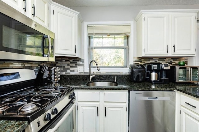 kitchen featuring stainless steel appliances, white cabinetry, a sink, and tasteful backsplash