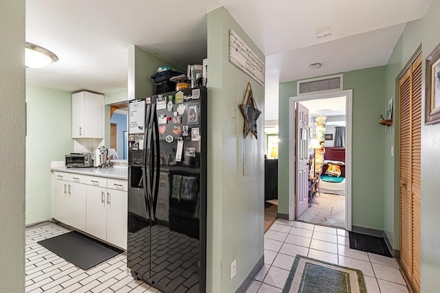 96 Old Colony Ave Unit 153, Taunton, MA 02718 - kitchen with black fridge with ice dispenser, white cabinets, light countertops, and light tile patterned floors