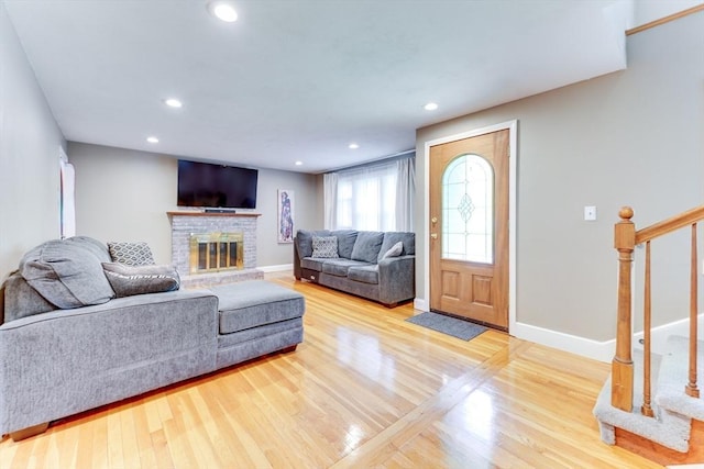 49 Hopkins Dr, Whitman, MA 02382 - living area with wood finished floors, baseboards, a brick fireplace, recessed lighting, and stairway