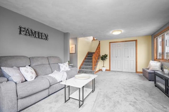 living room with stairs, carpet floors, and baseboards