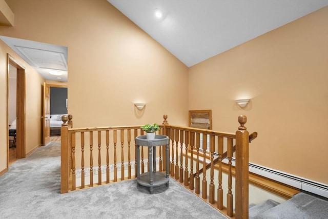 hall featuring attic access, an upstairs landing, carpet, and high vaulted ceiling