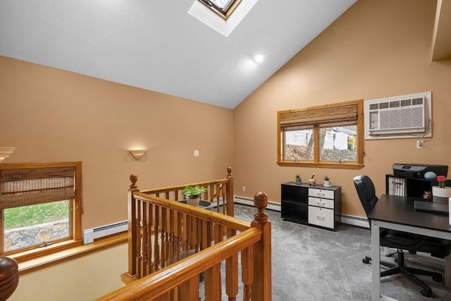 carpeted home office with vaulted ceiling with skylight, a healthy amount of sunlight, a baseboard radiator, and a wall unit AC