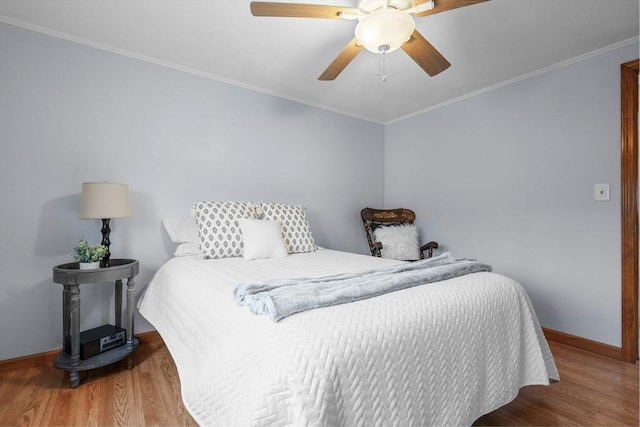 bedroom featuring baseboards, ornamental molding, a ceiling fan, and wood finished floors