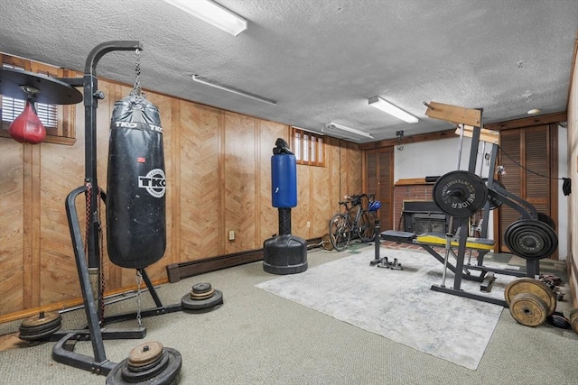 workout room featuring carpet, a textured ceiling, and wooden walls
