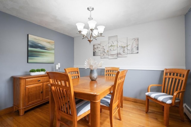 dining room featuring baseboards, a notable chandelier, and light wood-style flooring