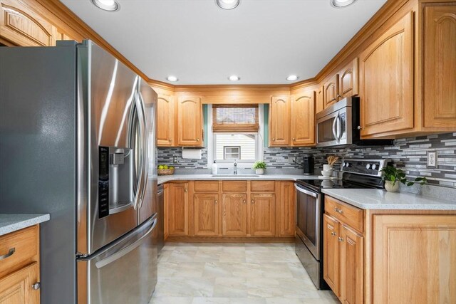 kitchen with a sink, stainless steel appliances, tasteful backsplash, and light countertops