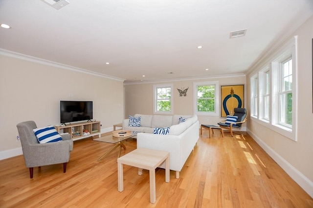 living room with ornamental molding and light hardwood / wood-style floors