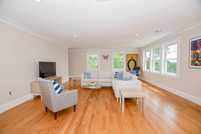 living room featuring crown molding, a wealth of natural light, and light wood-type flooring