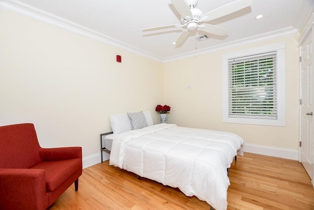 bedroom with hardwood / wood-style flooring, ornamental molding, and ceiling fan