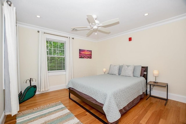 bedroom with crown molding, wood-type flooring, and ceiling fan