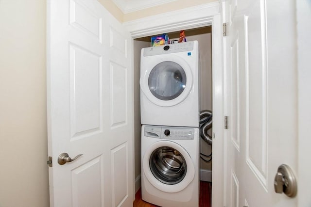 clothes washing area featuring stacked washer and clothes dryer and wood-type flooring