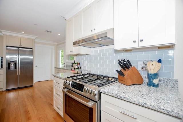 kitchen featuring light stone counters, backsplash, stainless steel appliances, and white cabinets