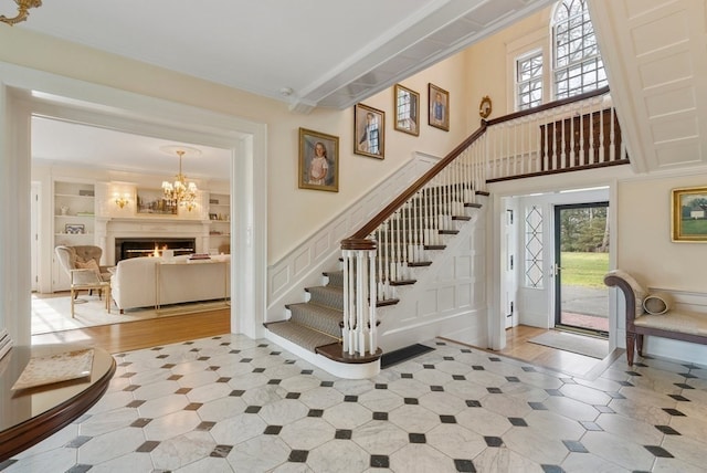 staircase with light tile flooring, built in shelves, and a notable chandelier