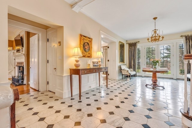 interior space with an inviting chandelier, crown molding, and light tile floors