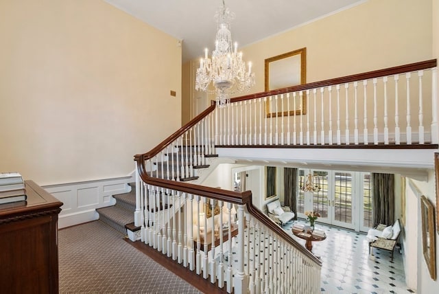 stairs featuring carpet, a high ceiling, and an inviting chandelier