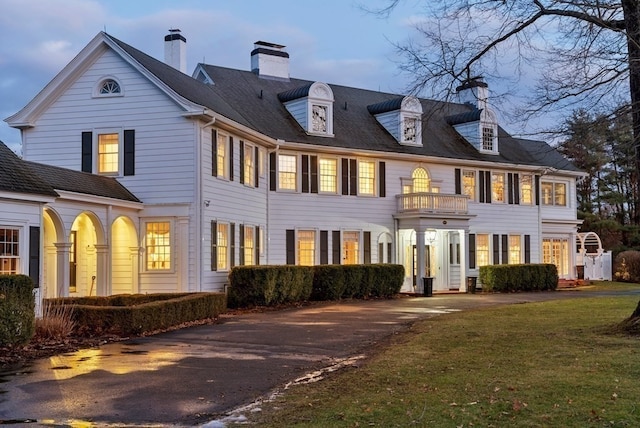 view of front of house featuring a front yard and a balcony