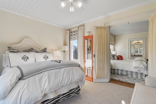 bedroom with ceiling fan, multiple windows, light wood-type flooring, and crown molding