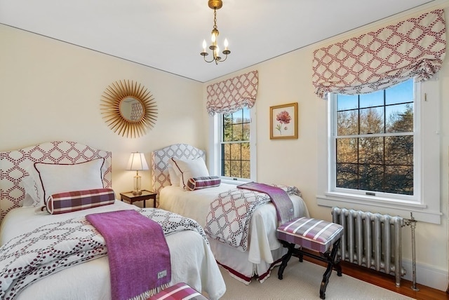 bedroom featuring a chandelier, light hardwood / wood-style floors, and radiator