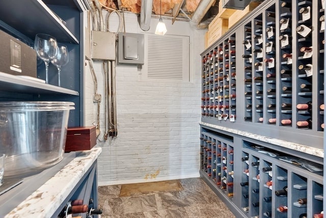 wine room with brick wall and dark tile flooring