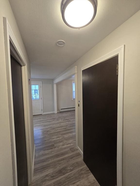 corridor with dark hardwood / wood-style flooring and a baseboard radiator