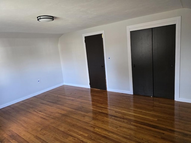 unfurnished bedroom with a closet and dark wood-type flooring