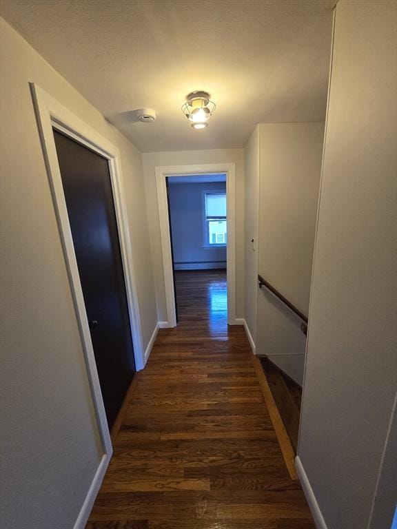 hallway featuring dark hardwood / wood-style floors and a baseboard radiator