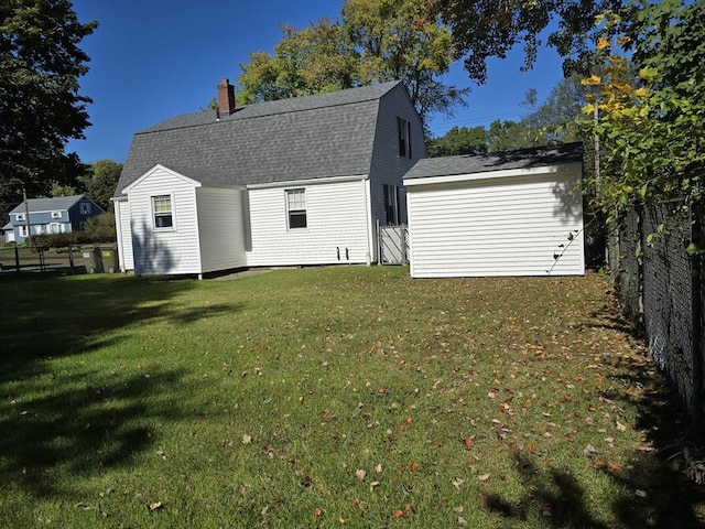 rear view of property featuring a lawn