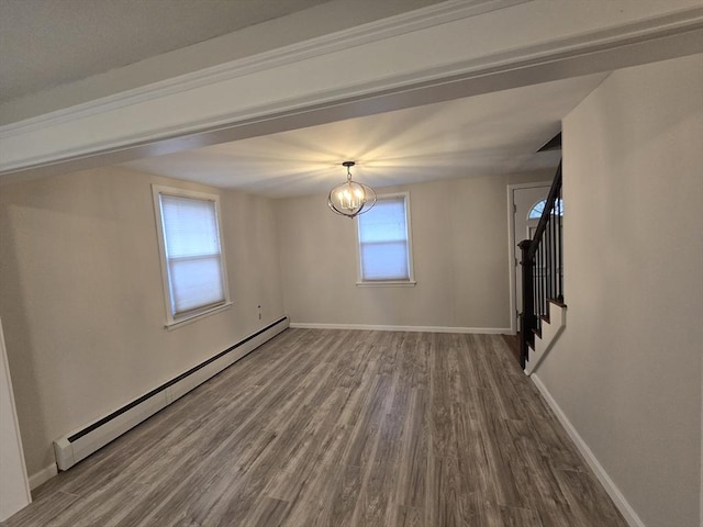 spare room with a chandelier, a baseboard radiator, and wood-type flooring