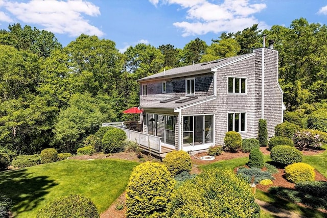 17 Claus, Barnstable, MA 02648 - rear view of property featuring a chimney, a lawn, and a wooden deck