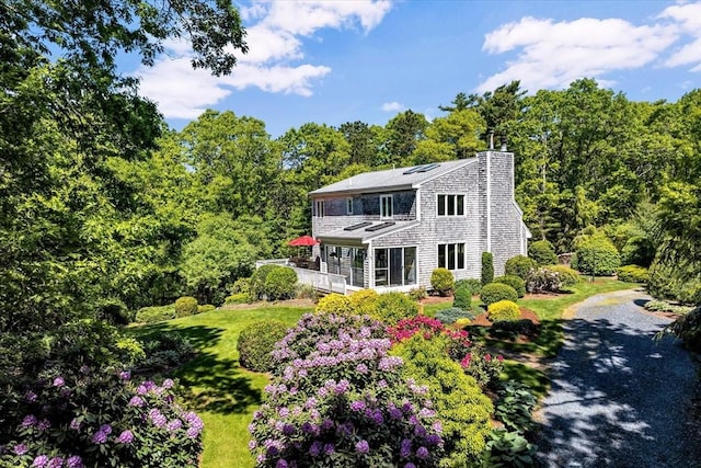 17 Claus, Barnstable, MA 02648 - view of front of property featuring solar panels, a chimney, and a front lawn