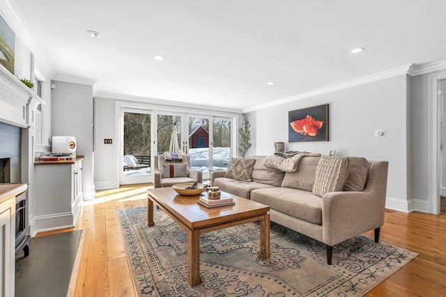 living room with crown molding, baseboards, recessed lighting, light wood-style flooring, and a fireplace