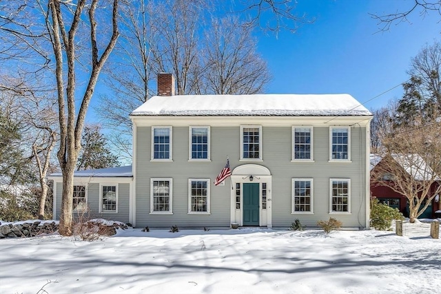 colonial-style house featuring a chimney