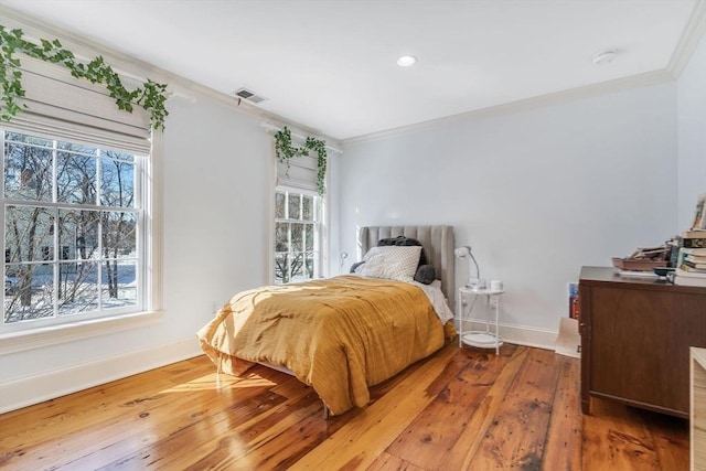 bedroom with multiple windows, visible vents, and ornamental molding